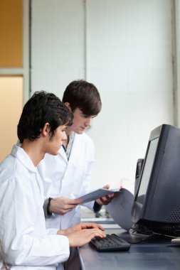 Portrait of male scientists using a monitor clipart