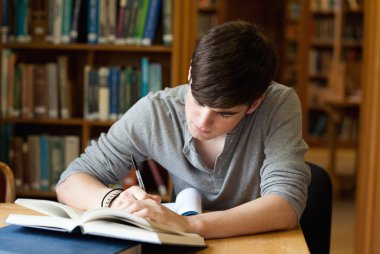 Focused male student working clipart