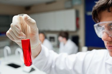 Scientist holding a test tube clipart