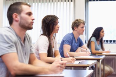 Studious young adults listening a lecturer clipart