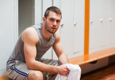 Young sports student sitting on a bench clipart