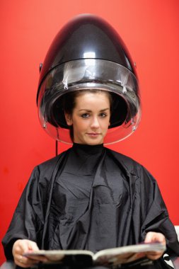 Portrait of a young woman under a hairdressing machine clipart