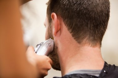 Young man having a haircut clipart