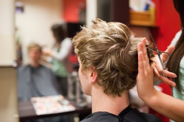 Blond-haired man having a haircut clipart