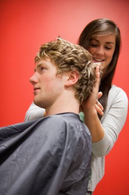 Portrait of a woman cutting a man's hair clipart