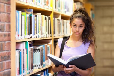 Serious female student holding a book clipart