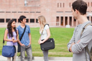 Student looking at his classmates talking clipart