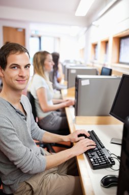 Portrait of a young male student posing with a computer clipart