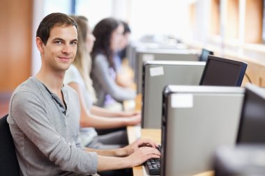 Smiling fellow students in an IT room clipart