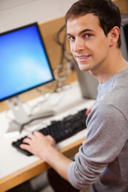 Portrait of a male student using a computer clipart