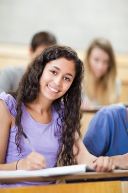 Portrait of a smiling student taking notes clipart