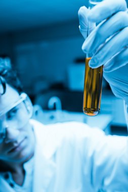 Portrait of a male scientist looking at a test tube clipart