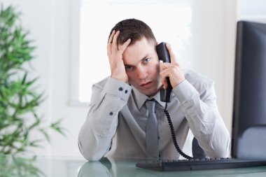 Close up of businessman getting sad news on the phone clipart