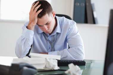 Close up of businessman frustrated with paperwork clipart