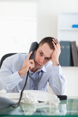 Close up of businessman trying to solve a problem on the phone clipart