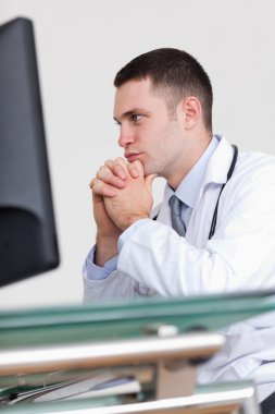 Close up of doctor reading something on his screen clipart