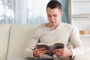 Young man reading a book clipart