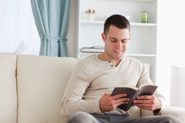 Handsome man reading a book clipart