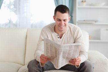 Happy man reading a newspaper clipart