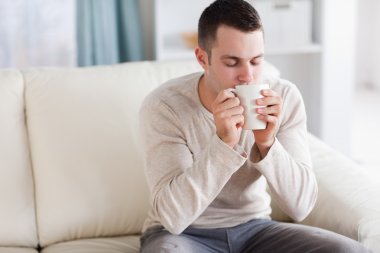 Good looking man having a tea clipart