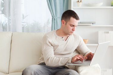 Man typing on his laptop clipart