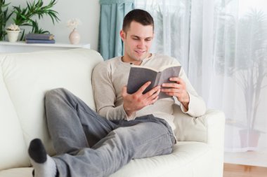 Smiling man reading a book clipart