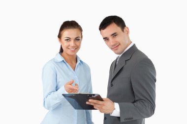 Smiling business partners with clipboard clipart