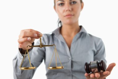 Scale and gavel being held by female lawyer clipart