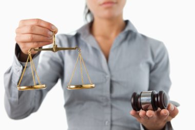 Gavel and scale being held by female lawyer clipart