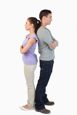 Young couple standing back-to-back clipart