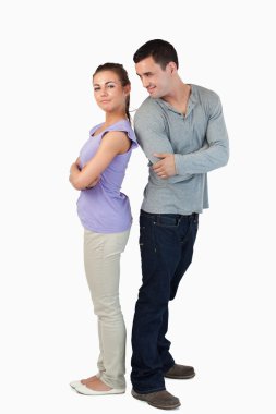 Young couple standing back-to-back to each other clipart