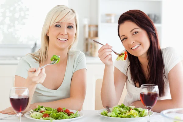 Glada unga kvinnor äter sallad — Stockfoto