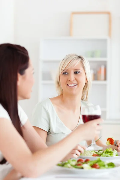 Retrato de mujeres alegres comiendo ensalada y bebiendo vino — Foto de Stock