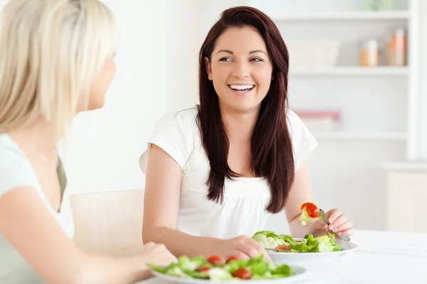 Porträtt av skrattar kvinnorna äta sallad — Stockfoto
