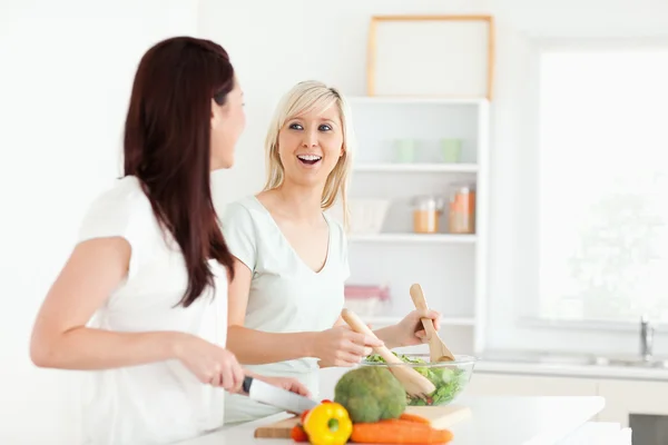 Jublande unga kvinnor förbereder middag — Stockfoto