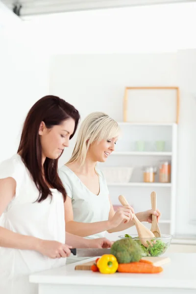 Lächelnde junge Frauen beim Zubereiten des Abendessens — Stockfoto