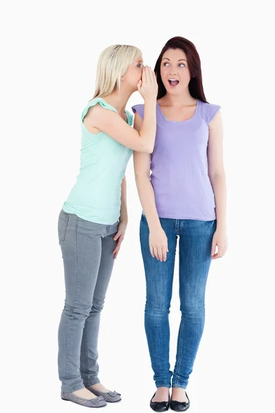 Mulher bonita dizendo a seu amigo um segredo — Fotografia de Stock