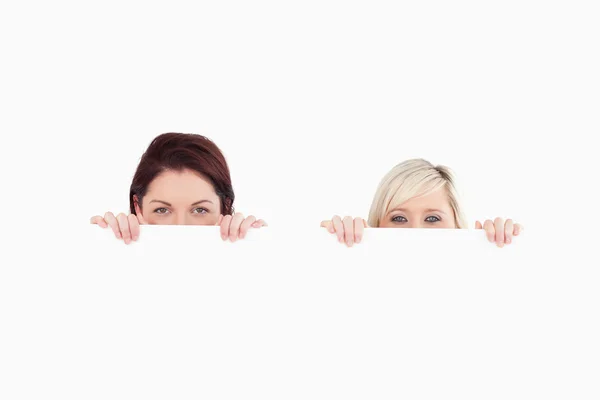 Women peeking over a banner — Stock Photo, Image