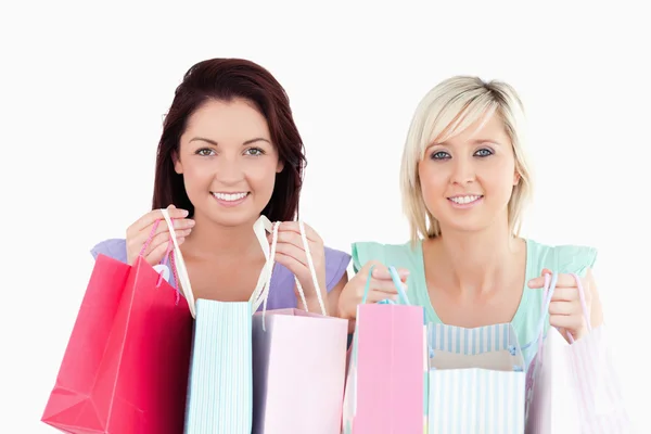 Vrolijke jonge vrouwen met shopping tassen — Stockfoto