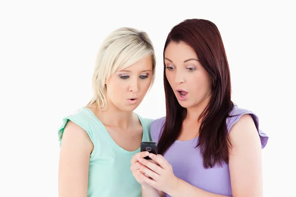 Jovens chocadas com um celular — Fotografia de Stock