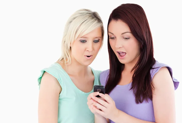Verbaasd jonge vrouwen met een mobiele telefoon — Stockfoto