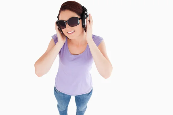 Usmívající se žena s sluchátka a sluneční brýle — Stock fotografie