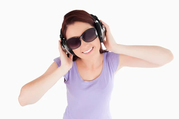 Κοκκινομάλλης γυναίκα με ακουστικά και γυαλιά ηλίου — Φωτογραφία Αρχείου