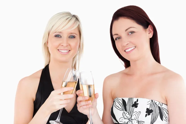 Lindas mujeres en hermosos vestidos tostadas con champaign —  Fotos de Stock