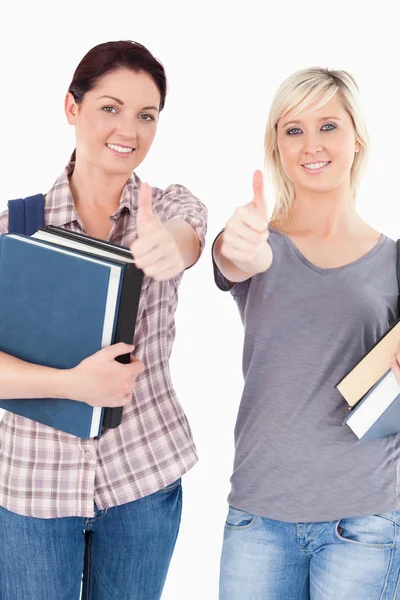 Students with books and thumbs up — Stock Photo, Image