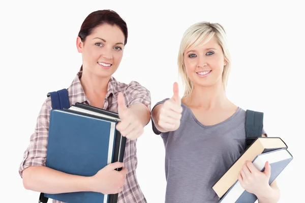 Estudantes do sexo feminino com livros e polegares para cima — Fotografia de Stock