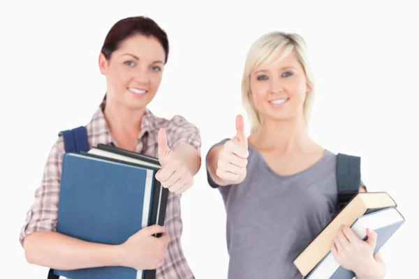 Two female students with books and thumbs up — Stock Photo, Image