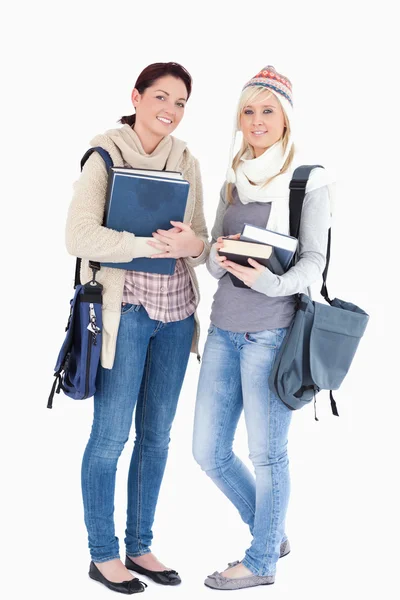Два студента с книгами, подготовленными к зиме — стоковое фото