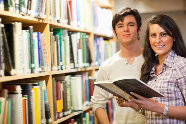 Young students holding a book — Stock Photo, Image