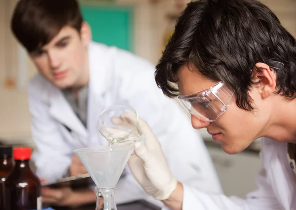 Närbild på studenter i kemi att göra ett experiment — Stockfoto